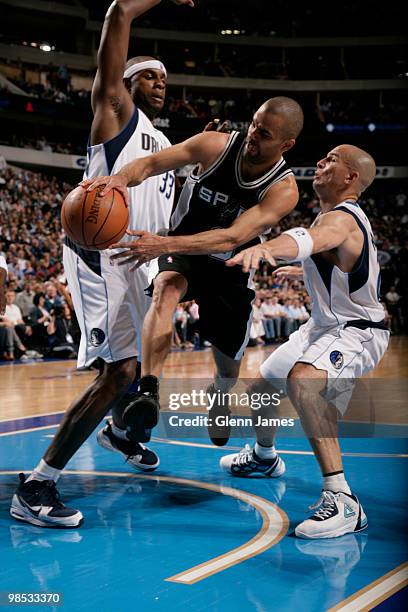 Tony Parker of the San Antonio Spurs wraps a pass around against Brendan Haywood and Jason Kidd of the Dallas Mavericks in Game One of the Western...