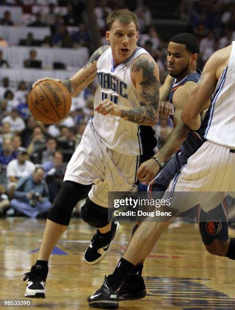 Jason Williams of the Orlando Magic drives around D.J. Augustin of the Charlotte Bobcats in Game One of the Eastern Conference Quarterfinals during...