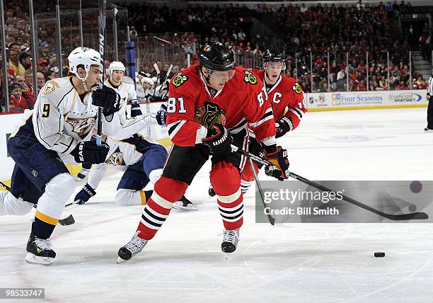 Marian Hossa of the Chicago Blackhawks approaches the puck as Marcel Goc of the Nashville Predators skates in from the boards at Game Two of the...