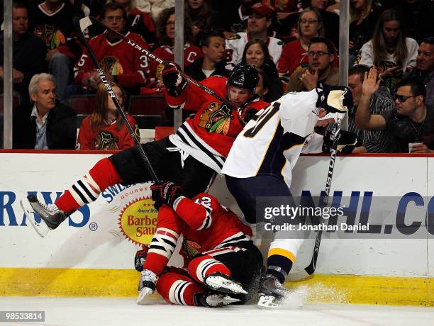 Troy Brouwer of the Chicago Blackhawks falls over teammate Kris Versteeg as they battle for the puck with Ryan Suter of the Nashville Predators in...