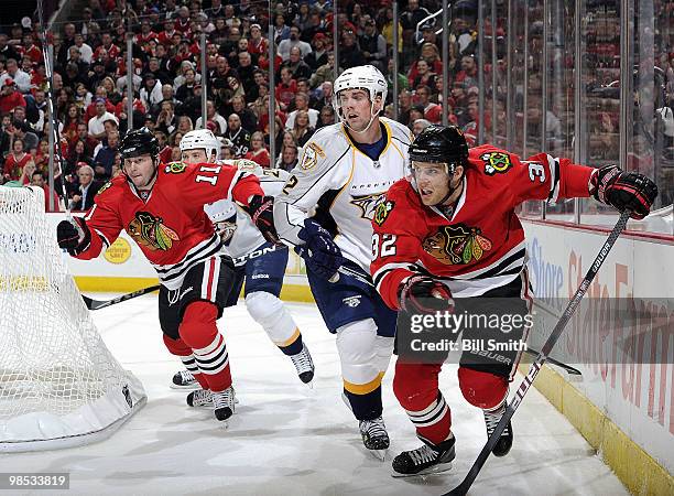 Kris Versteeg and John Madden of the Chicago Blackhawks chase after the puck as Dan Hamhuis of the Nashville Predators follows behind at Game Two of...