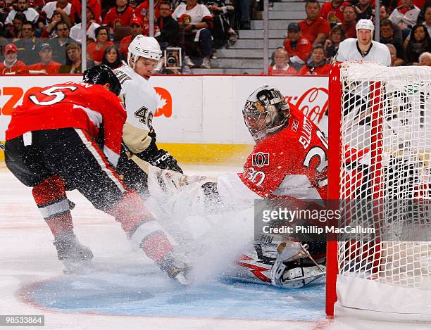 Brian Elliott of the Ottawa Senators makes a glove save while teammate Andy Sutton tries to defend against Tyler Kennedy of the Pittsburgh Penguins...