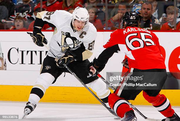 Sidney Crosby of the Pittsburgh Penguins looks to deke around Erik Karlsson of the Ottawa Senators during Game 3 of the Eastern Conference...