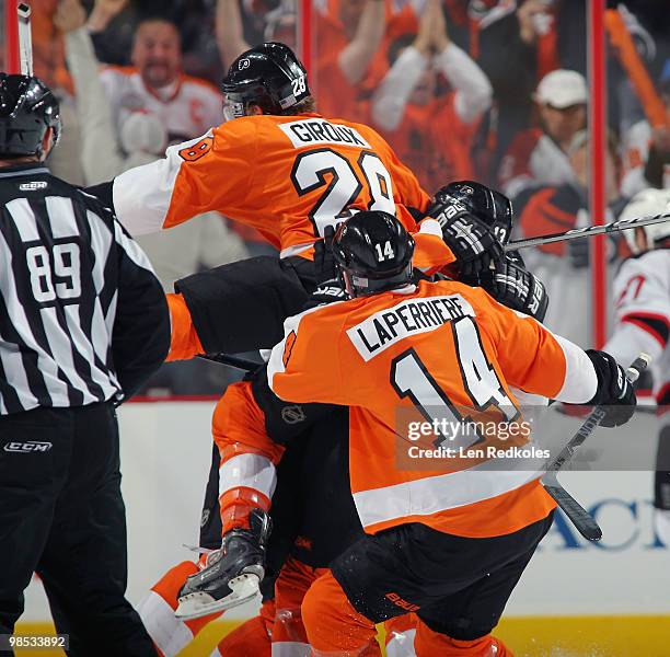 Dan Carcillo of the Philadelphia Flyers is mobbed by his teammates Claude Giroux and Ian Laperriere after scoring the game-winning goal against the...