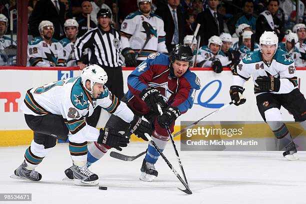 Ryan Wilson of the Colorado Avalanche battles for the puck against Scott Nichol of the San Jose Sharks in Game Three of the Western Conference...