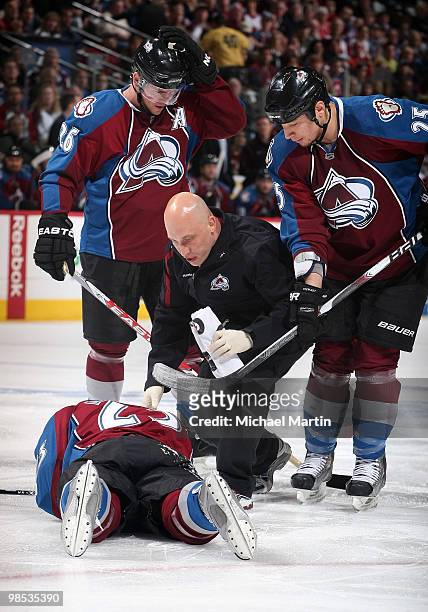 Head athletic trainer Matthew Sokolowski of the Colorado Avalanche checks on Milan Hejduk after he collided with a teammate during the previous play...