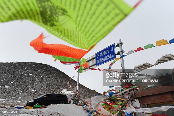 Tibetan prayer flags on the roof of the world adorn a marker along the Bayankela Pass at 4,824 meters on the Qinghai-Tibet plateau where much of the...