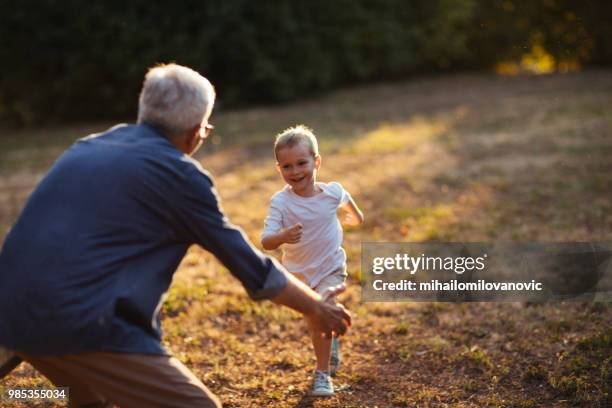 heureux garçon courir pour embrasser son grand-père - mihailomilovanovic photos et images de collection