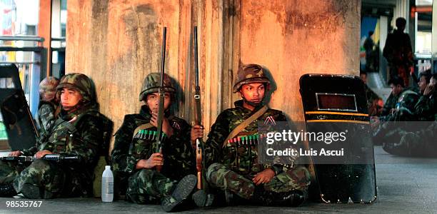 Thai army soldiers rest while securing the walkway of a skytrain station in Bangkok's Silom district early morning as Red shirt supporters of ousted...