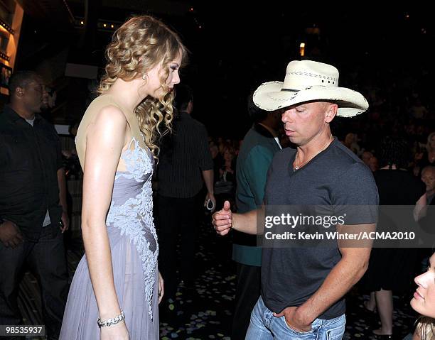 Singer Taylor Swift and musician Kenny Chesney speak in the audience during the 45th Annual Academy of Country Music Awards at the MGM Grand Garden...