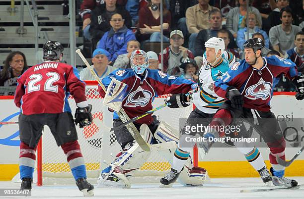 Goalie Craig Anderson of the Colorado Avalanche keeps his eye on the puck along with Ryane Clowe of the San Jose Sharks and Scott Hannan and Kyle...