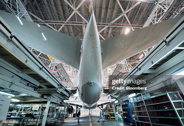 Mechanic walks past a newly delivered Boeing 777-300ER passenger jet for All Nippon Airways Co. In the company's hanger at Narita Airport in Chiba...