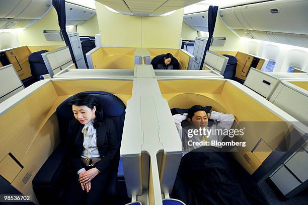 Employees sit in the seats of the first class cabin as they introduce All Nippon Airways Co.'s new branded service "Inspiration of Japan" inside a...