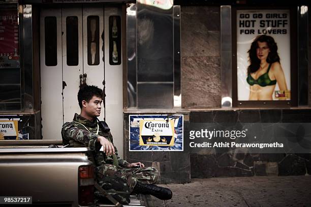 Thai army soldier sit and relax outside a go-go bar at Bangkok's Silom district as Red shirt supporters of ousted premier Thaksin Shinawatra threaten...