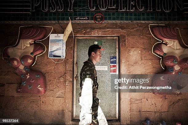 Thai army soldier walks past a go-go bar at Bangkok's Silom district as Red shirt supporters of ousted premier Thaksin Shinawatra threaten to take...