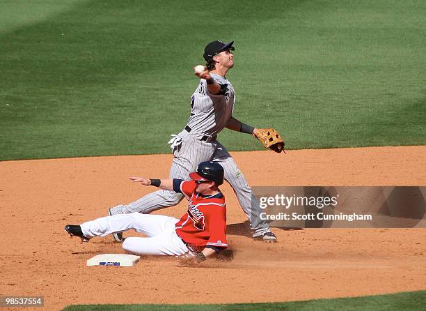 Troy Tulowitzki of the Colorado Rockies attempts to turn a 9th inning double play against Nate McLouth of the Atlanta Braves at Turner Field on April...