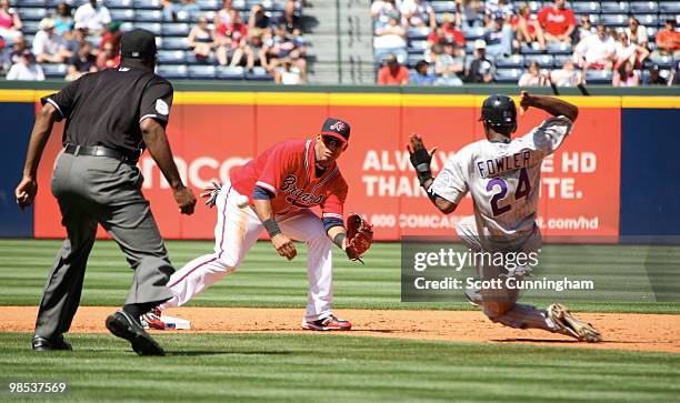 Yunel Escobar of the Atlanta Braves waits for a throw against Dexter Fowler of the Colorado Rockies at Turner Field on April 18, 2010 in Atlanta,...
