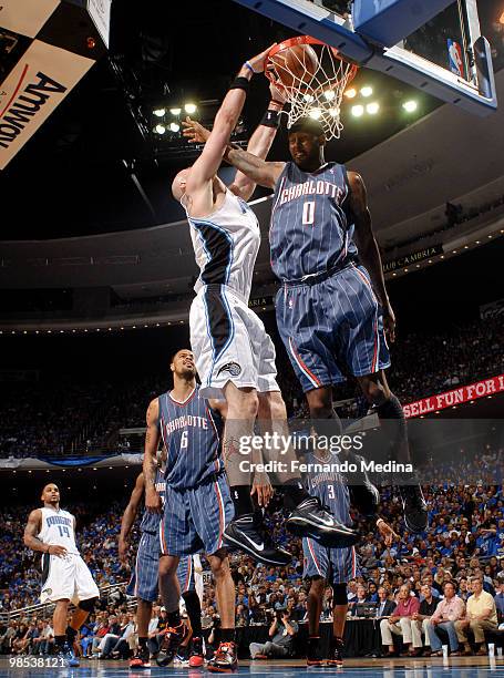 Marcin Gortat of the Orlando Magic dunks against Larry Hughes of the Charlotte Bobcats in Game One of the Eastern Conference Quarterfinals during the...