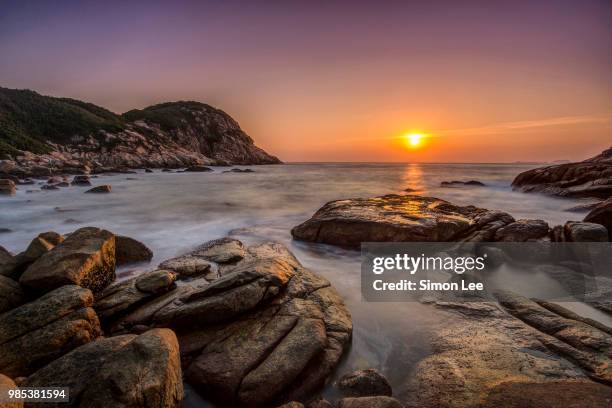 sunrise off the coast of shek o in hong kong. - simon o stock pictures, royalty-free photos & images