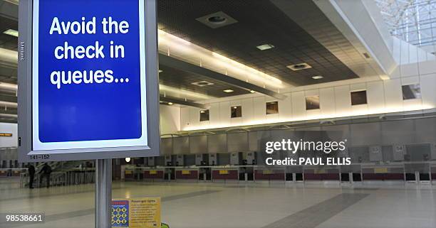 Sign above a self check-in machine is pictured in a empty departure lounge at Manchester Airport in north-west England, on April 19, 2010. Britain is...