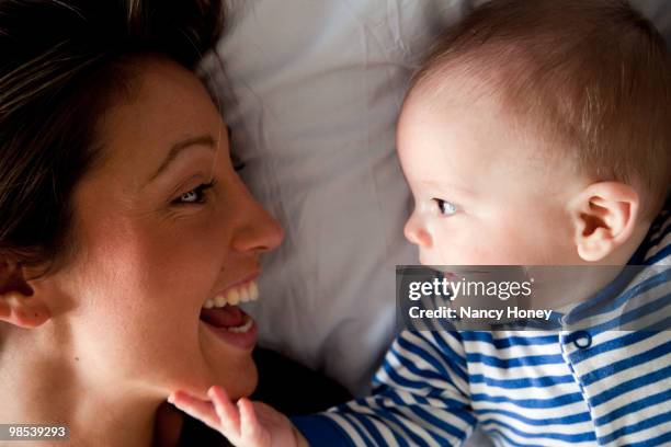 close-up of mother and baby laughing together - newfamily stock pictures, royalty-free photos & images