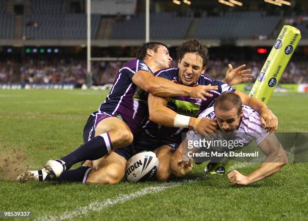 Michael Robertson of the Sea Eagles scores a try under pressure from Billy Slater and Cooper Cronk of the Storm during the round six NRL match...