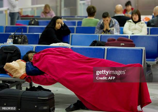 Passenger sleeps on seats at Gatwick airport in southern England, on April 19 following the closure of the airport due to volcanic ash emitted from...