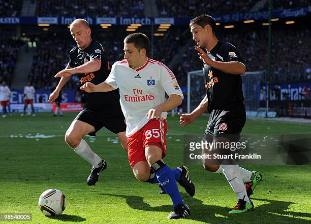 Tunay Torun of Hamburg is challenged by Miroslav Karhan and Malik Fathi of Mainz during the Bundesliga match between Hamburger SV and FSV Mainz 05 at...