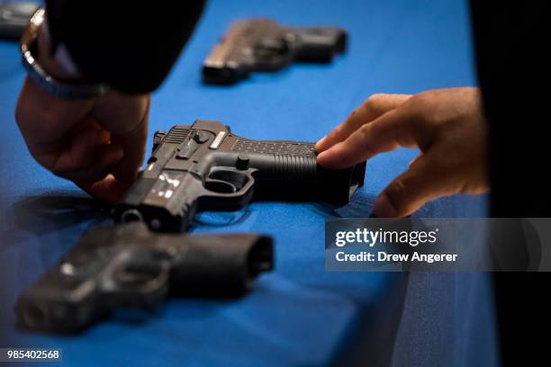 Member of the NYPD lays out guns recovered by police during a press conference about gang violence at New York City Police Department headquarters,...
