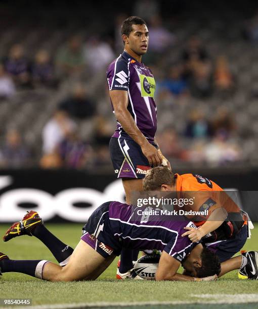 Greg Inglis of the Storm is assisted by a trainer during the round six NRL match between the Melbourne Storm and the Manly Sea Eagles at Etihad...