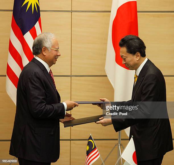 Japanese Prime Minister Yukio Hatoyama exchanges documents with Prime Minister of Malaysia Najib Tun Razak at the premier's official residence on...