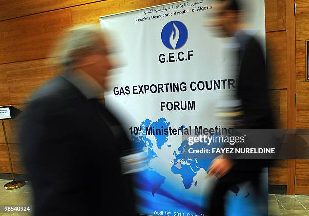 Staff pass by the posters during the opening ceremony of the of the 'Gaz Exporting Meeting Forum' 10th Ministerial Meeting at the Covention Centrein...