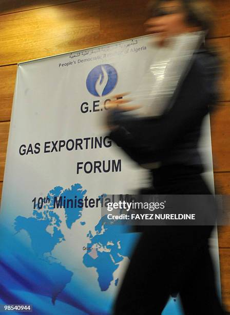 Staff pass by the posters during the opening ceremony of the of the 'Gaz Exporting Meeting Forum' 10th Ministerial Meeting at the Covention Centrein...