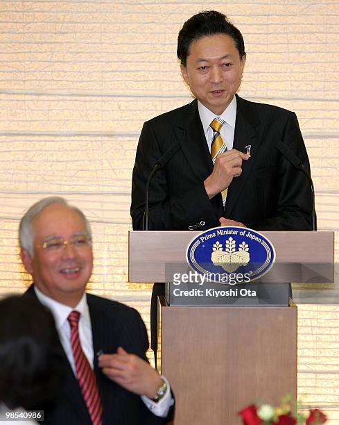 Japanese Prime Minister Yukio Hatoyama gestures as he delivers a speech while Malaysian Prime Minister Najab Razak smiles during a welcome dinner...