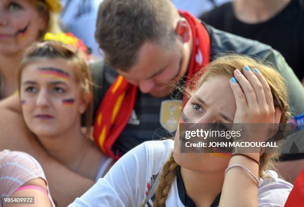 Supporter of the German national football look dejected at a public viewing event at the Fanmeile in Berlin to watch the Russia 2018 World Cup Group...