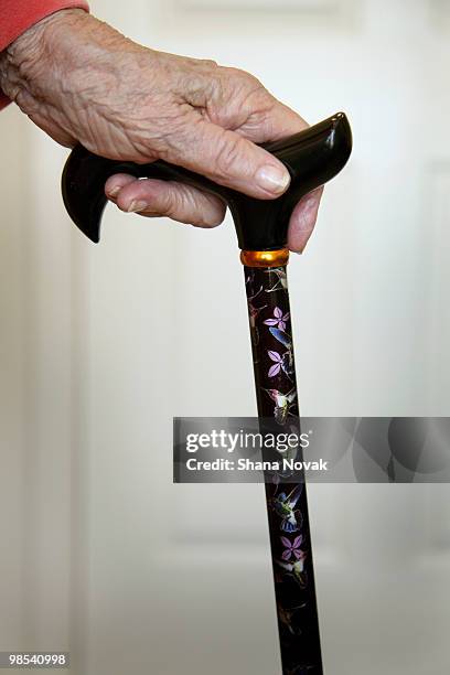 senior woman holds cane - shana novak imagens e fotografias de stock