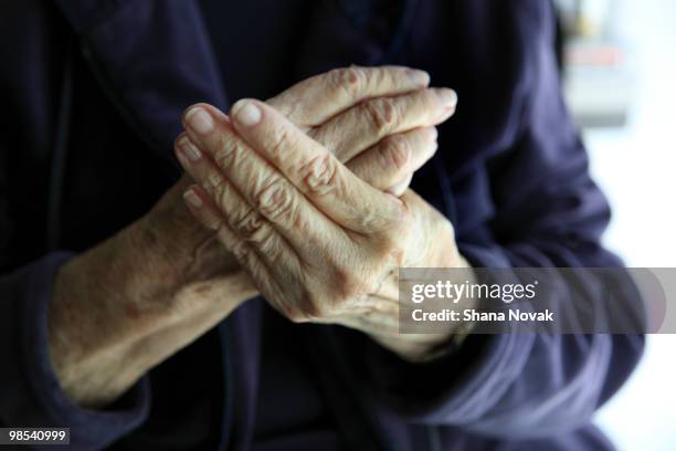 senior woman rubs painful hands - shana novak stock pictures, royalty-free photos & images