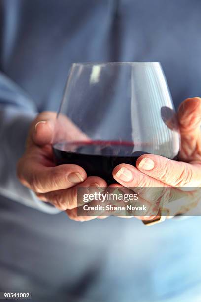 senior woman holding red wine - shana novak stock pictures, royalty-free photos & images