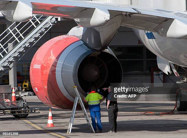 Technicians check for eventual volcano ashes in a motor of the first airplane to land on Arlanda Airport, in Stockholm, on April 19, 2010. The Airbus...