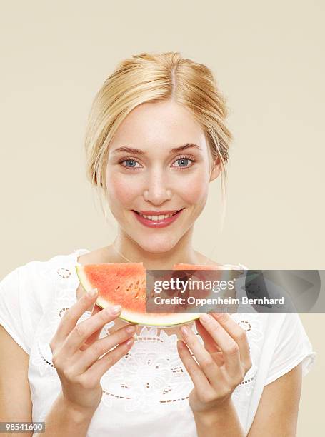 woman smiling holding a slice of watermelon - 5 am tag stock-fotos und bilder