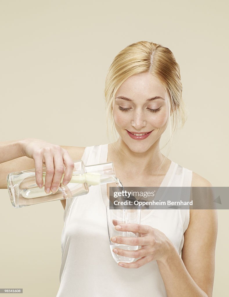Woman smiling whilst pouring a glass of water