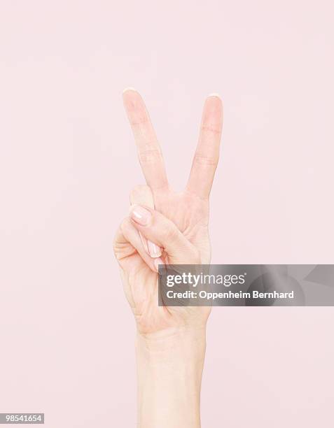 female hand making peace sign - victory sign stock-fotos und bilder