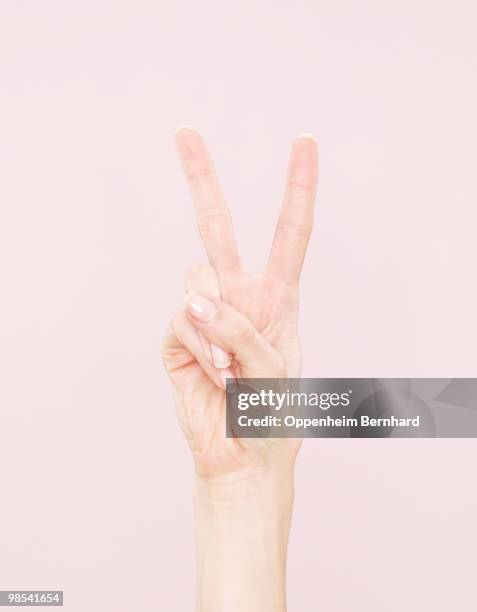 female hand making peace sign - gesto de victoria fotografías e imágenes de stock