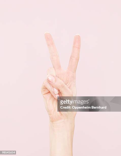 female hand making peace sign - geste de la main photos et images de collection