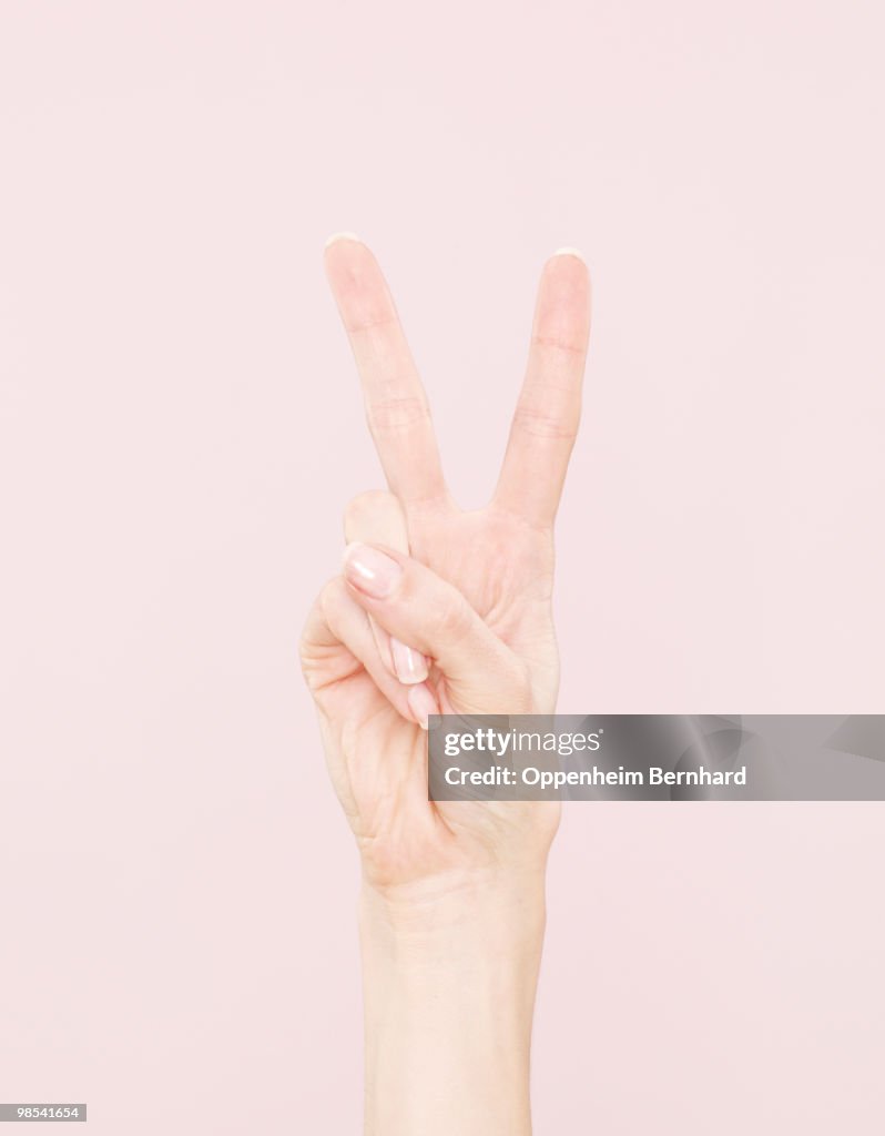 Female hand making peace sign