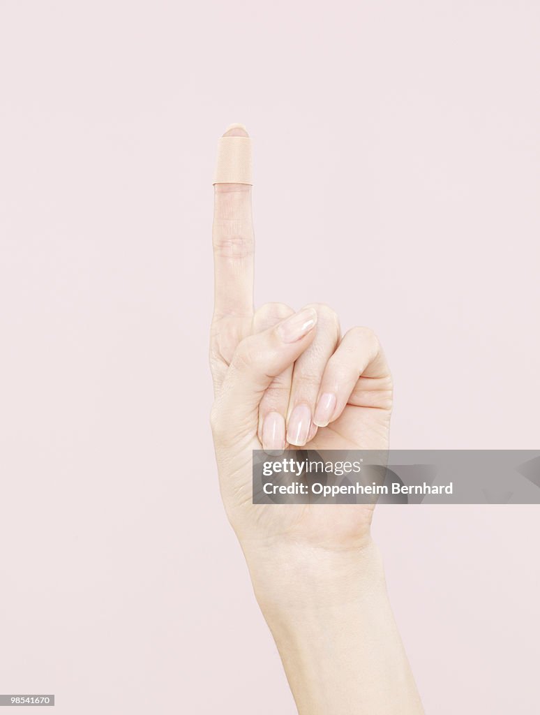 Female hand with plaster on index finger