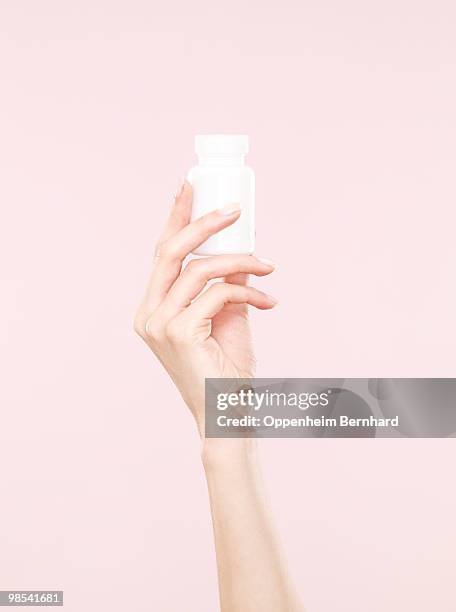 female hand holding tub of tablets - holding imagens e fotografias de stock