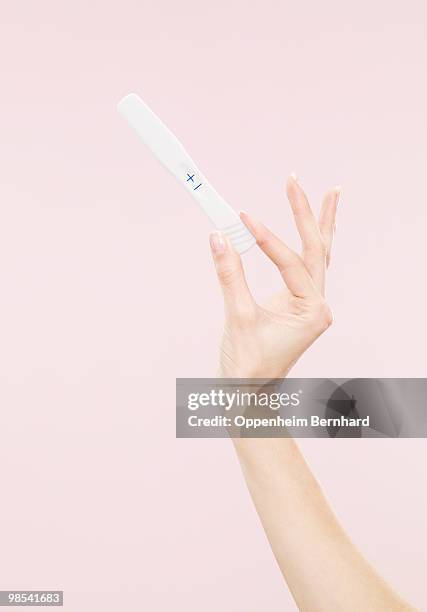 female hand holding positive pregnancy test - pregnancy test stock pictures, royalty-free photos & images