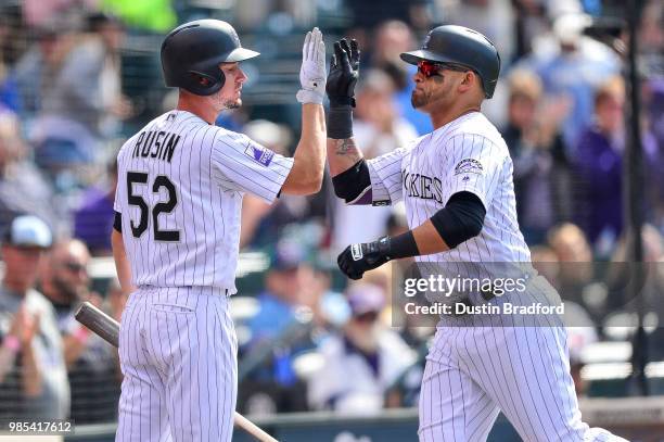 Gerardo Parra of the Colorado Rockies celebrates a run scored with Chris Rusin at Coors Field on June 24, 2018 in Denver, Colorado.