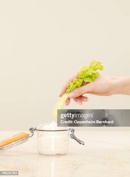 female hand dipping celery into pot of humous - dipping stock pictures, royalty-free photos & images